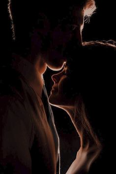 a man and woman kissing in the dark