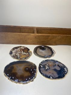 four agate stone coasters sitting on top of a white counter next to a wooden box