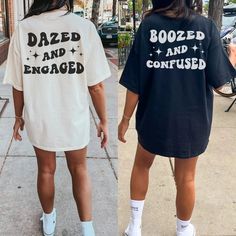 two women walking down the street wearing matching shirts and shorts that read dazed and engaged