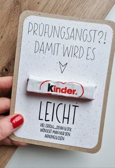 a person holding a candy bar on top of a piece of paper that says kinder