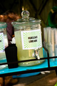 there are many cups and jars on the table with labels in them that say nuclear limeade
