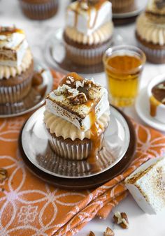 cupcakes with caramel and whipped cream on top are sitting on a plate