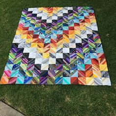 a patchwork quilt is laying on the grass