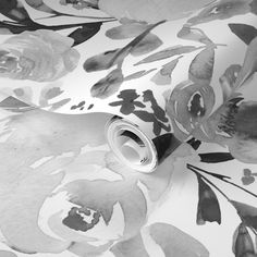 black and white floral wallpaper with watercolor flowers on the back ground, as well as a roll of tape