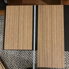 two pieces of wood sitting next to each other on top of a carpeted floor