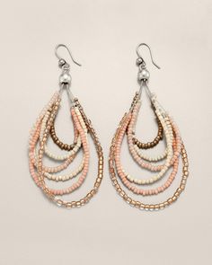 a pair of pink and white beaded earrings with pearls on the bottom, hanging from silver hooks
