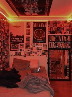 a bedroom with red lights and posters on the wall above the bed, along with bookshelves