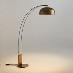 a floor lamp with a wooden base and a metal light shade on the top of it