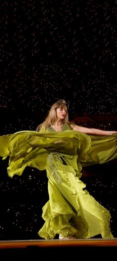 a woman in a yellow dress is dancing