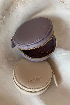 two small round purses sitting on top of a white surface