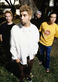 a group of men standing next to each other on top of a grass covered field