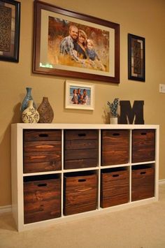 an entertainment center with drawers and pictures on the wall