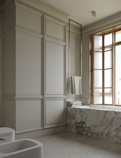 a large bathroom with marble counter tops and white walls, along with two sinks on either side of the bathtub