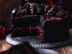 a piece of cake with chocolate skulls on top and berries in the middle is sitting on a plate