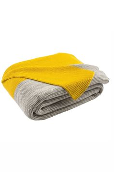 the yellow and grey blanket is folded on top of each other with two different colors