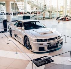 a silver sports car on display in a building