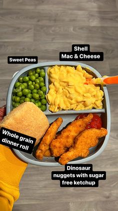 a person holding a plate with different types of food on it, including macaroni and cheese