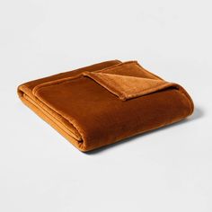 a brown blanket folded on top of a white surface