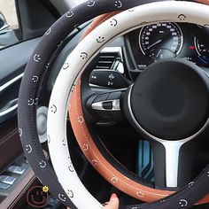 the steering wheel cover is decorated with black and white circles, which also have orange trims
