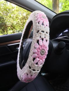 a car steering wheel cover with crocheted flowers on the front and back wheels