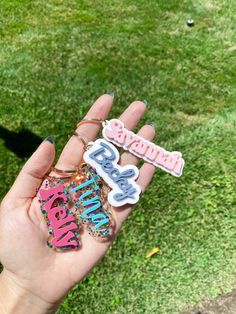 someone is holding up some type of brooch that says happy birthday in pink and blue