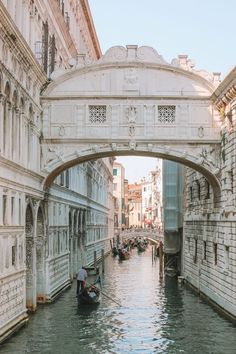 a gondola going under an overpass on a canal in venice, italy