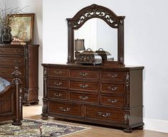 a bedroom scene with focus on the dresser and bed, along with an ornate mirror