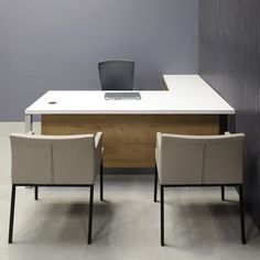 an office desk with two chairs and a laptop on it