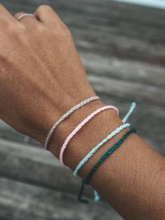 a person wearing three different bracelets on their arm