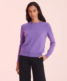 a woman wearing a purple sweater and black pants