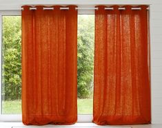 an orange curtain hanging in front of a window