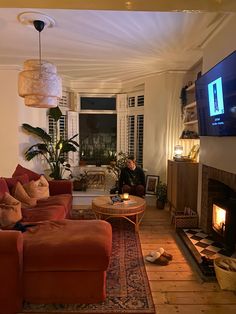 a living room filled with furniture and a flat screen tv mounted on the wall above a fire place
