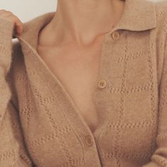 a woman wearing a tan cardigan sweater with buttons