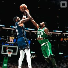 two basketball players in the air with a ball near one another and an audience watching