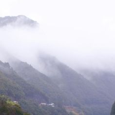 the mountains are covered in thick fog and low lying clouds, as well as houses