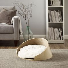 a living room with a couch, chair and bookcase in the middle of it