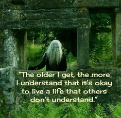 an old man with long white hair sitting in the middle of a stone structure surrounded by ferns