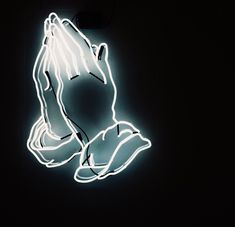 a neon sign that is lit up in the dark with someone's hands on it