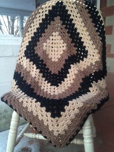 a crocheted blanket sitting on top of a wooden chair