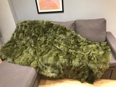 a large green shaggy rug on top of a couch