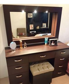 a dresser with a mirror and stool underneath it