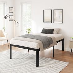 a bedroom with white walls and wooden floors