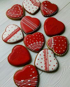 decorated cookies arranged in the shape of heart's on a white table with red and white decorations