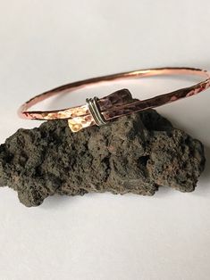 Rustic yet pretty copper bangle with a sterling silver detail The bangle is made of 2.6 mm copper wire, the ends was flatten and tied with sterling silver wire, then soldered (bangle is not adjustable).  This bangle will look good on its own, in combination with other bangles and can be worn by women and men, which is made it as a perfect gift for 7th wedding Anniversary for her or for him. It can be made in different sizes, so what if both of you would have matching bangles? Please choose size by the internal diameter.  The bangle is not covered with any lacquer, so it has all the copper's benefits.  For more versatile bangle please check out my shop www.leofwinejewellery.etsy.com Hammered Copper Jewelry, Hammered Metal Jewelry, Copper Jewelry Diy, Handmade Copper Bracelet, 7th Wedding Anniversary, Hammered Jewelry, Copper Jewellery, Hammered Bangles, Copper Wire Jewelry