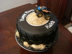 a black and white birthday cake with a toy truck on top