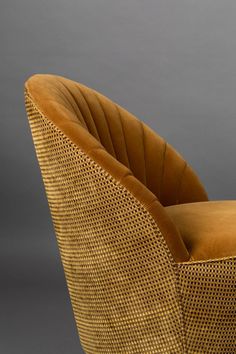 an upholstered chair with gold colored cushions