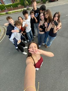 a group of young people standing in the middle of a street with their hands together