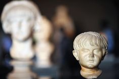 a close up of a statue of a child's head on a chess board