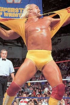 the wrestler is holding up his yellow shirt