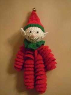 a crocheted christmas ornament hanging on a wall in the shape of a gnome